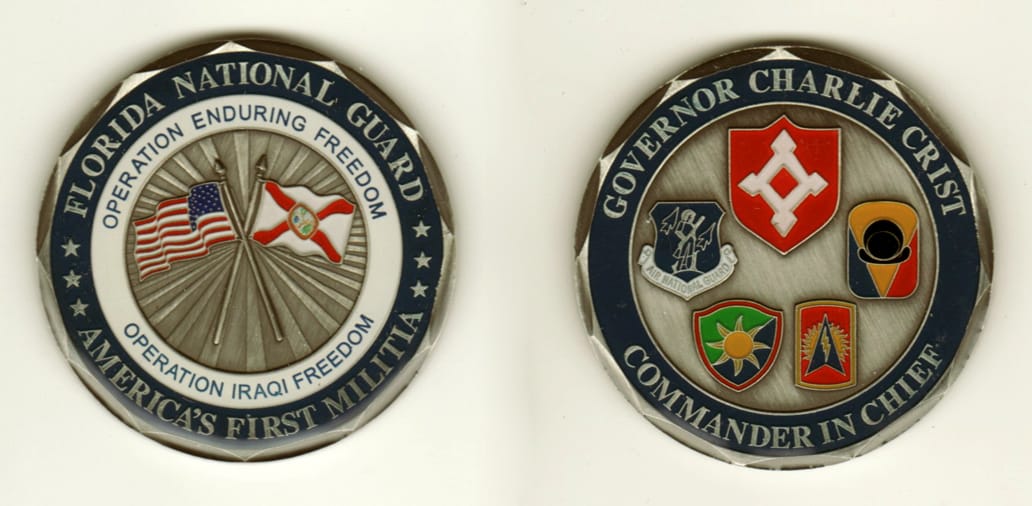 Round shaped, pewter colored coin, 2 inches in diameter.