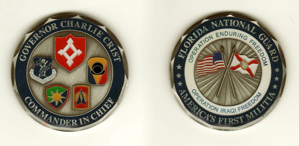 Round shaped, pewter colored coin, 2 inches in diameter.