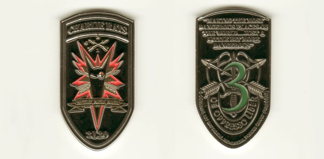 Elongated shield shaped, silver colored coin, 1 1/8 inches wide x 2 1/8 inches high.