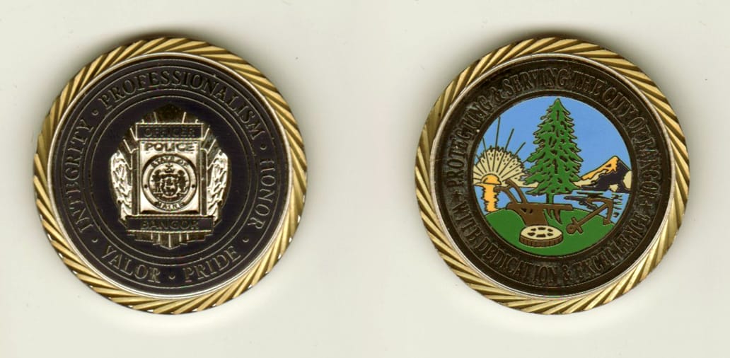 Round shaped, silver colored coin with gold colored rim, 1 1/4 inches in diameter.