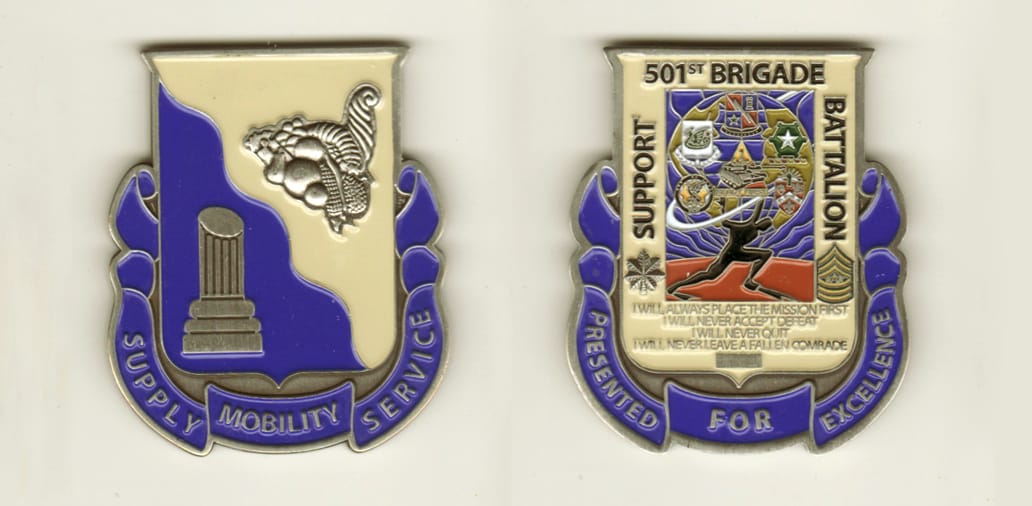 Shield shaped with ribbon banner mounted below and up sides, pewter colored coin, 2 inches wide x 2 1/4 inches high.