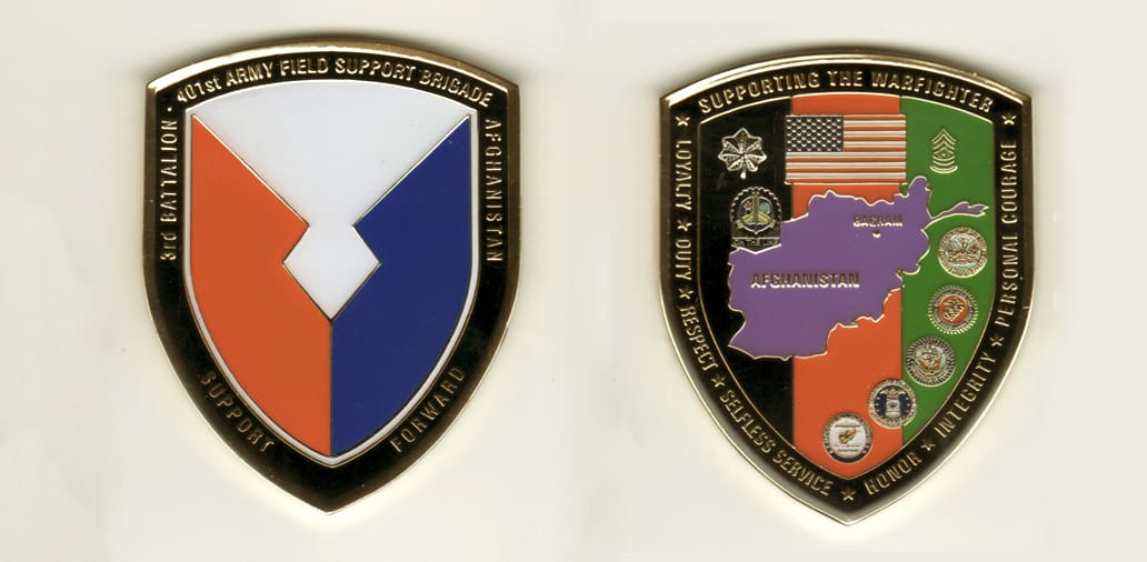 Shield shaped, brass colored coin, 2 3/4 inches high x 2-1/4 inches wide.