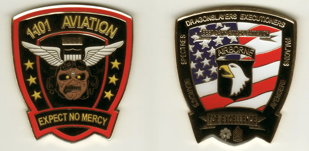 Shield shaped with banner across base of shield, yellow gold colored coin 2 inches wide x 2-1/4 inches high.