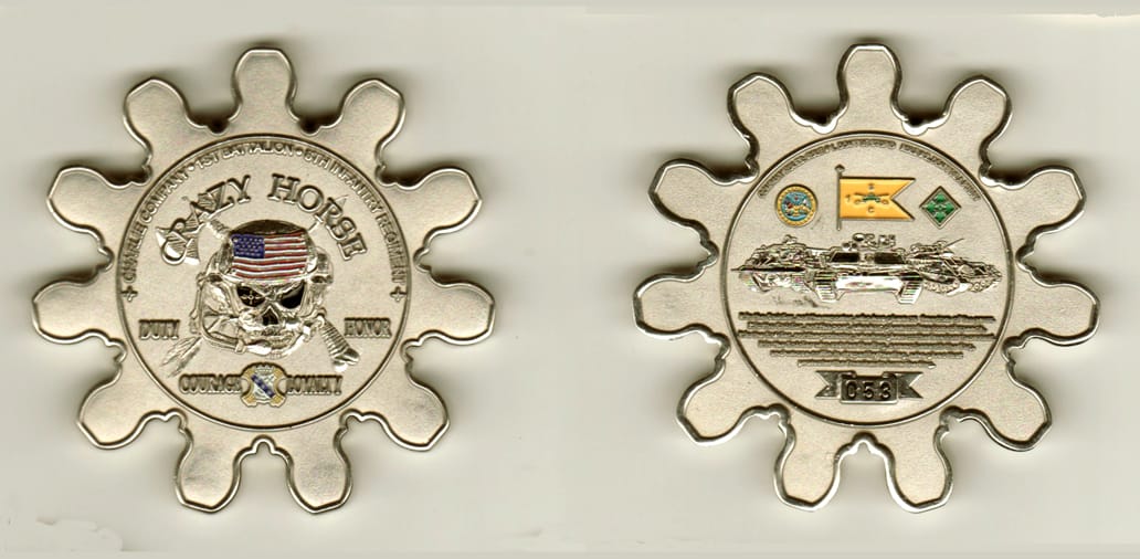 Round  cog shaped, silver colored coin- 2 1/2 inches in diameter.