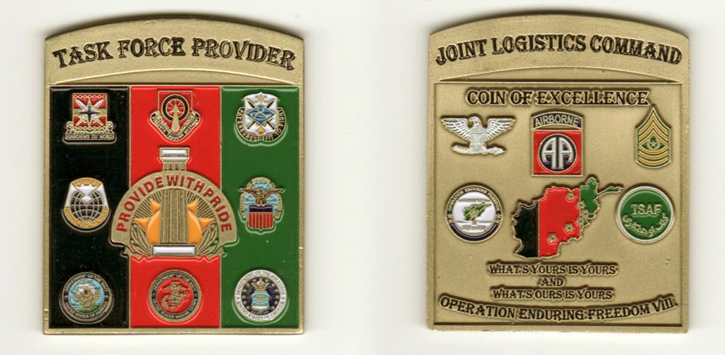 Square shaped, with banner mounted above, antique brass colored coin, 2 inches wide x 2-1/2 inches high.