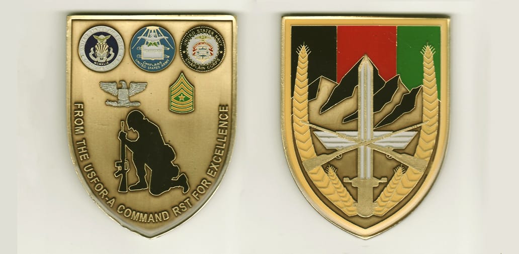 Shield shaped, brass colored coin, 3-1/2 inches high x 2-3/4inches wide.