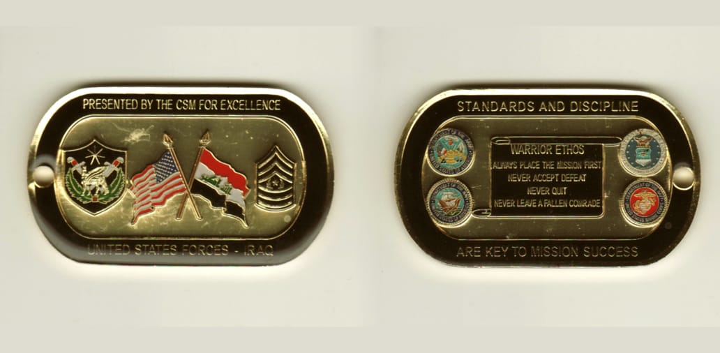 Dog tag shaped, gold colored coin, 2 inches wide x 1-1/4 inches high.