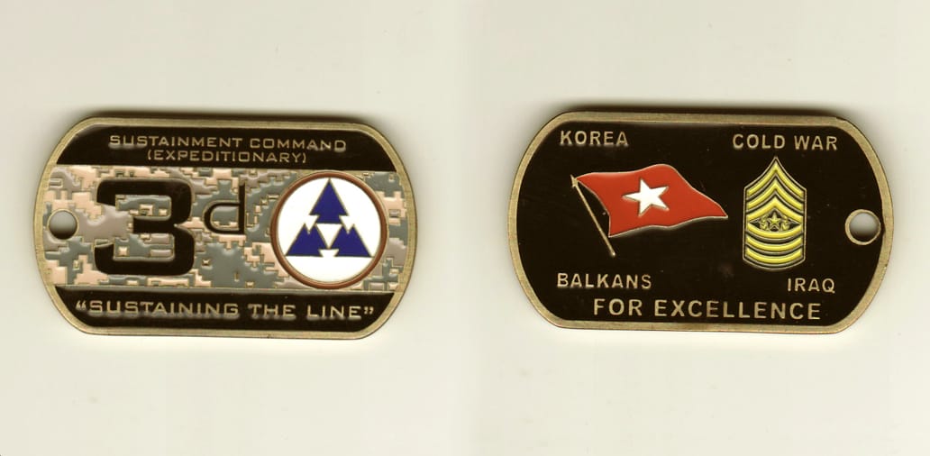 Dog tag shaped, brass colored coin, 2-1/4 inches wide x 1-1/4 inches high.