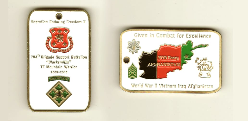 Dog tag shapped, brass colored coin,1-1/4 inches wide x 2 inches high.