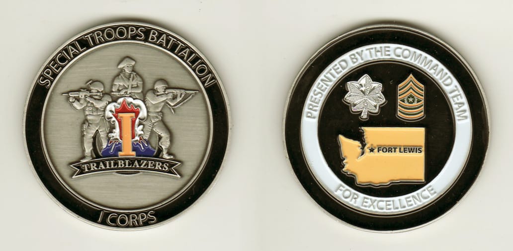 Round shaped, pewter colored coin, 2 inches in diameter.