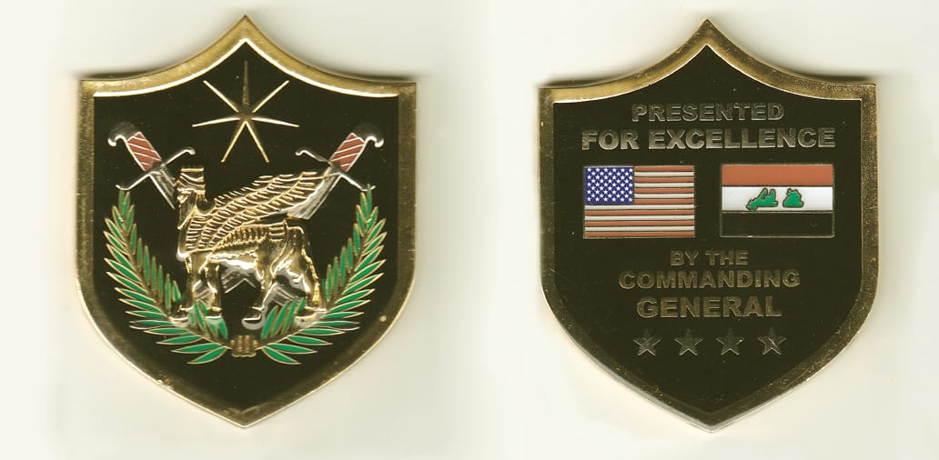 Shield shaped, gold colored coin, 2-1/2 inches wide x 3 inches high.