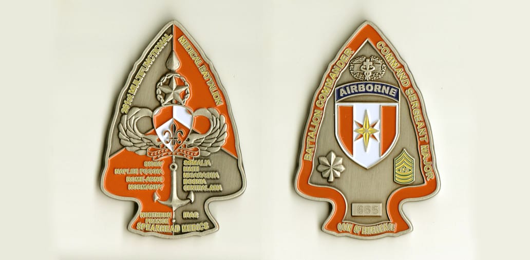 Arrowhead shaped, gold colored coin, 2 inches wide x 3 inches high.