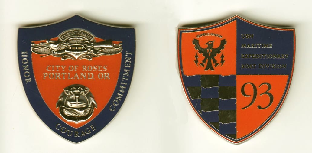 Shield shaped, silver colored coin, 1-3/4 inches wide x 1-7/8 inches high.