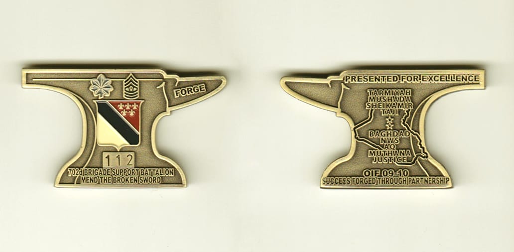 Anvil shaped, brass colored coin, 2 inches wide x 1-3/16 inches high.