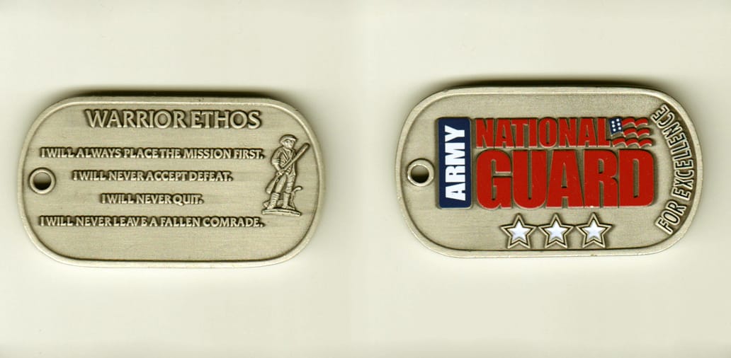 Dog tag shaped, pewter colored coin, 2-1/4 inches wide x 1-1/4 inches high.