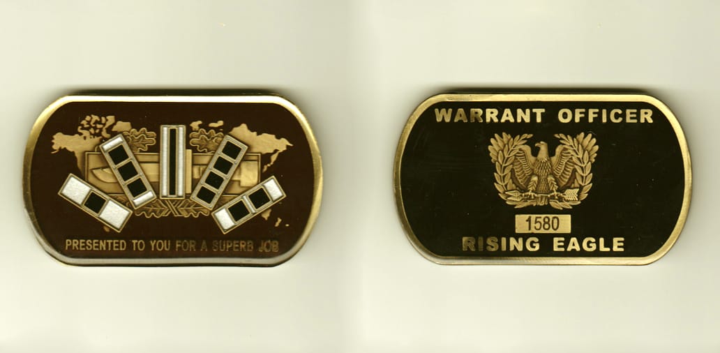 Dog tag shaped, gold colored coin, 3 inches wide x 1-1/2 inches high.