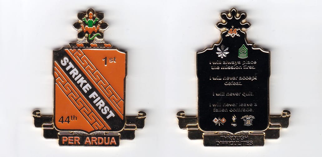 Shield shaped, with banner mounted beneath and flower mounted above, gold colored coin, 2 inches wide x 2-1/2 inches hig...