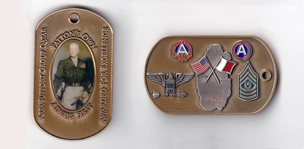 Dog tag shaped, brass colored coin, 1-1/2 inches wide x 2-1/2 inches high.