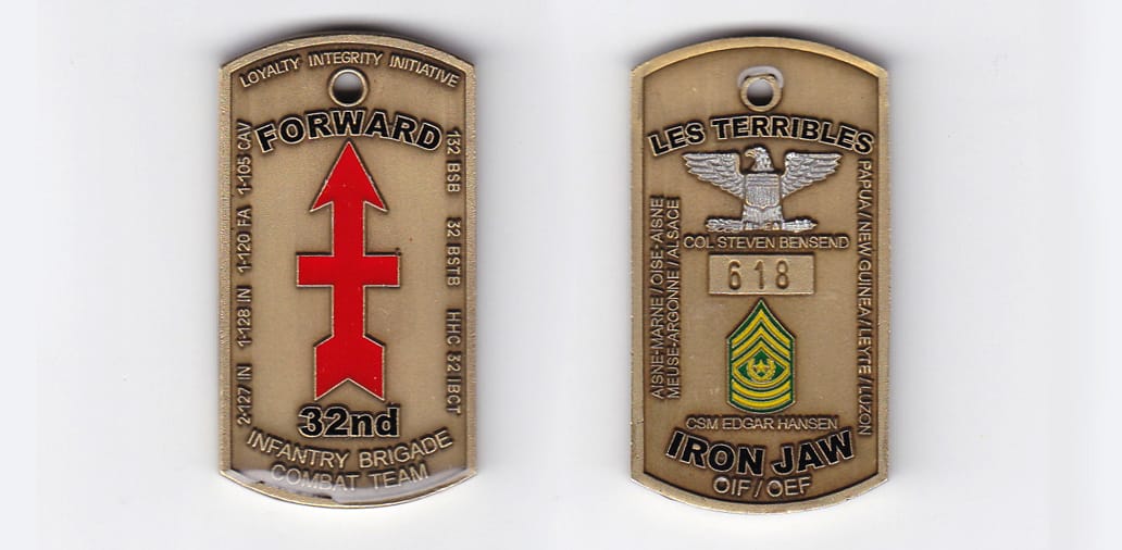 Dog tag shaped, brass colored coin, 1-1/2 inches wide x 2-1/8 inches high.