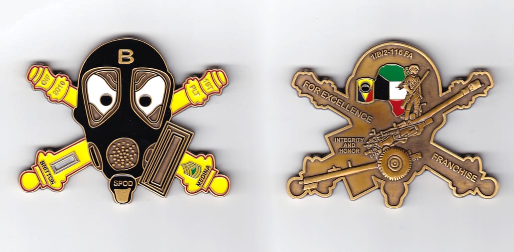 Gas mask shaped, with crossed cannons extending, brass colored coin 3 inches wide x 2-1/2 inches high.