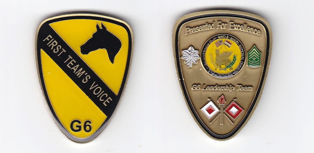 Shield shaped, brass colored coin 1-1/2 inches wide x 2-1/16 inches high.