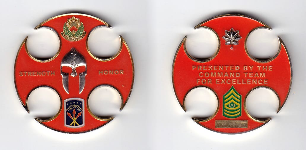 Round shaped with four cut out circles intersecting edge of coin, gold colored coin, 2 inches in diameter.