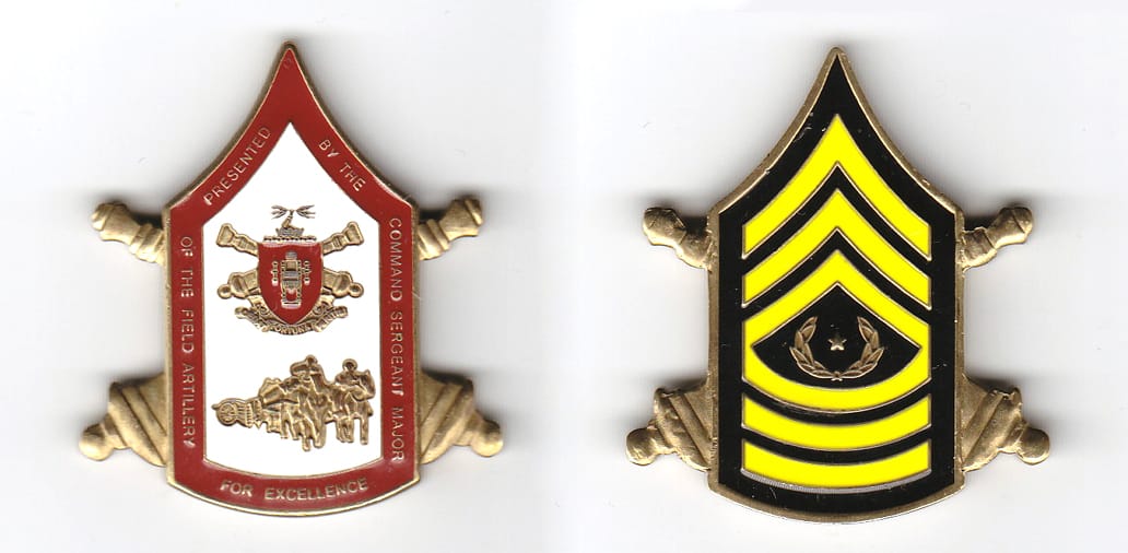 CSM chevron shaped, with crossed cannons extended, brass colored coin 1-1/2 inches wide x 2 inches high.