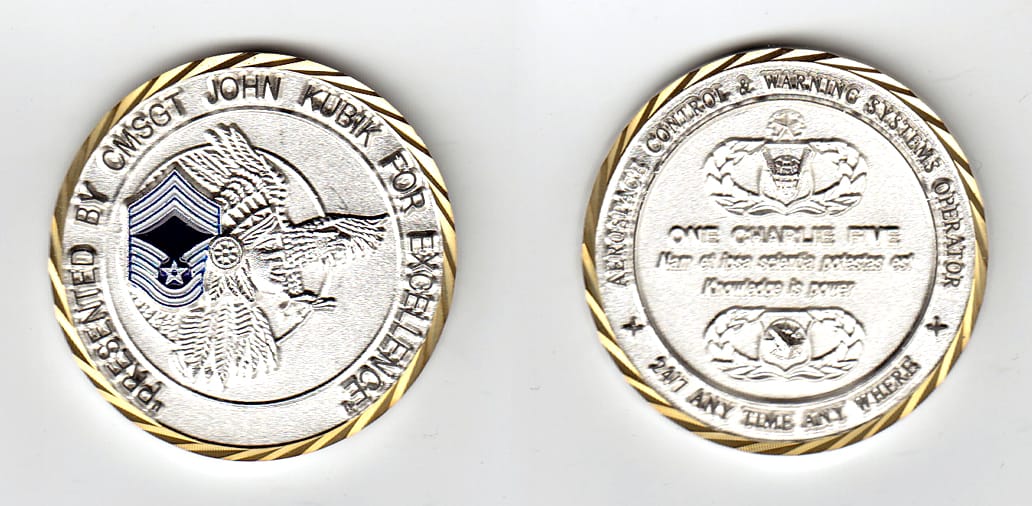 Round shaped, silver colored coin, 2 inches in diameter.