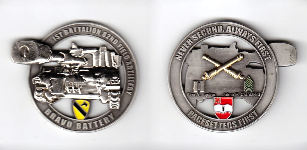 Round shaped with tank turret gun extended, pewter colored coin, 2 inches in diameter.