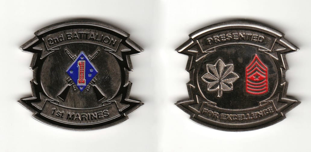 Oval shaped with banners mounted above and beneath, silver colored coin 2 inches wide x 1-3/4 inches high.