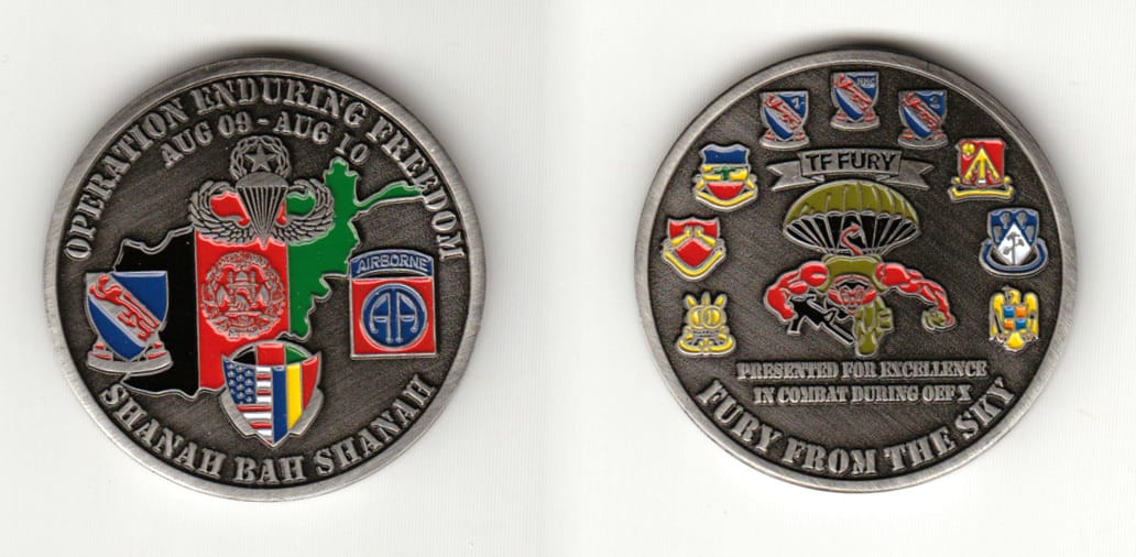 Round shaped, gun metal black colored coin 1-3/4 inches in diameter.