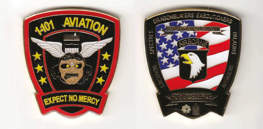 Shield shaped, gold colored coin 2 inches wide x 2-1/4 inches high.