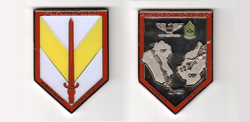 Shield shaped, silver colored coin 2-1/8 inches wide x 3 inches high.