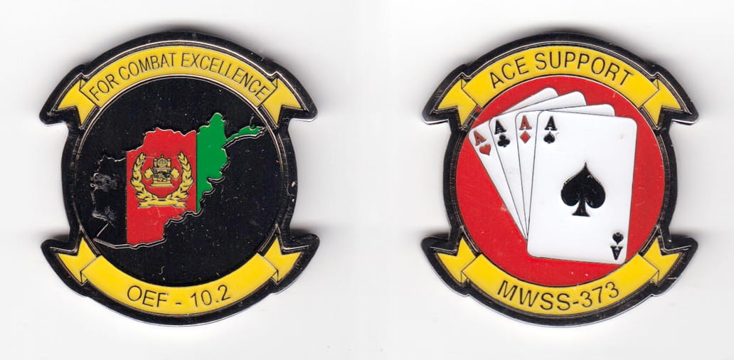 Round shaped, with banner mouned above and beneath, silver  colored coin 1-5/8 inches wide x 1-3/4 inches high.