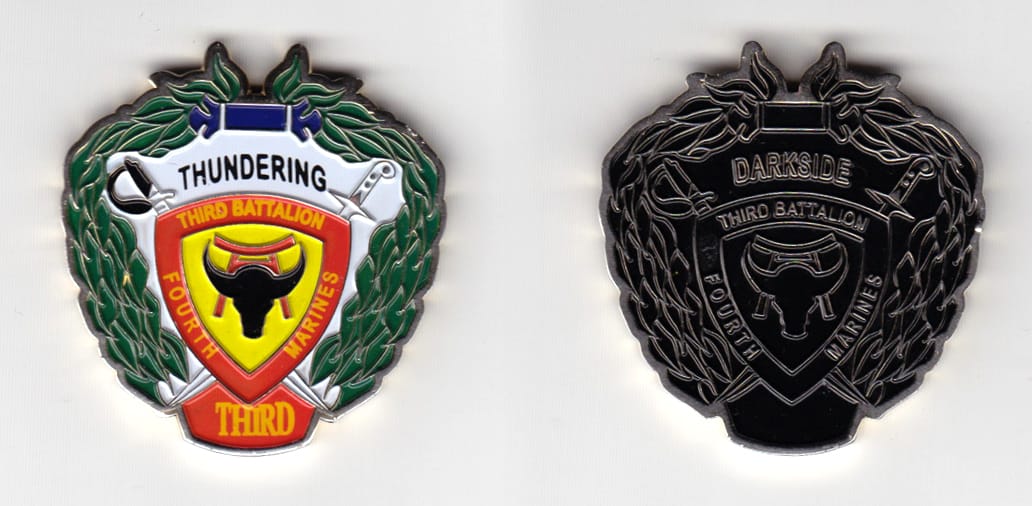 Shield shaped, with wreaths mounted top and sides, brass  colored coin 1-5/8 inches wide x 1-3/4 inches high.