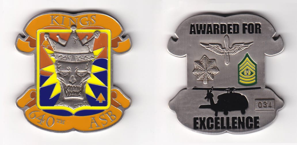 Shield shaped with banner mounted on top and bottom, pewter colored coin, 2-1/2 inches wide x 2-1/2 inches high.