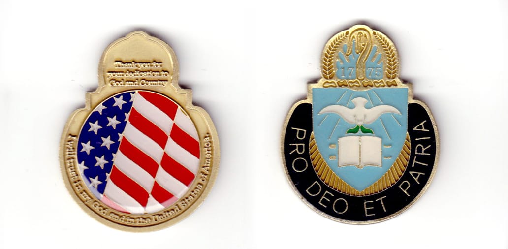 Round shaped, with top of shield and arch protruding above, brass colored coin, 1-3/4 inches wide x 2-1/4 inches high.