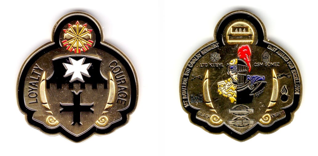 Rounded shield shaped with half circle shape protruding from top, gold colored coin, 2 inches wide x 2 inches high.