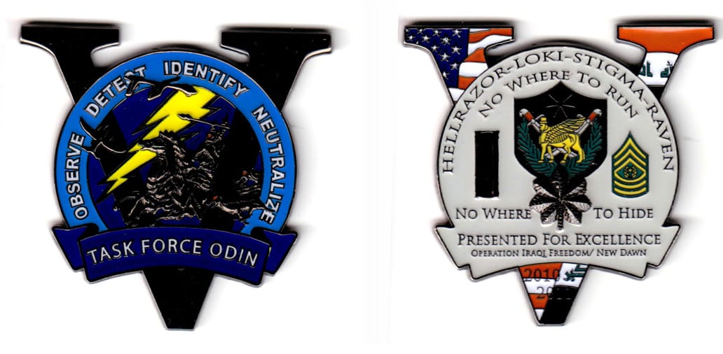 V shaped with banner mounted circular shape protruding black colored coin, 2-12 inches wide x 2-1/4 inches high.