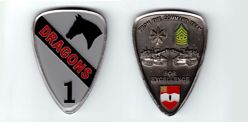 Shield shaped, silver colored coin, 1-3/4 inches wide x 2-3/8 inches high.