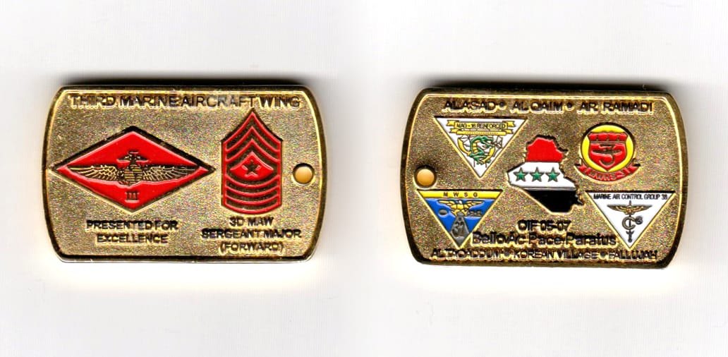 Dog tag shaped, brass colored coin, 1-11/16 inches wide x 1-1/16 inches high.