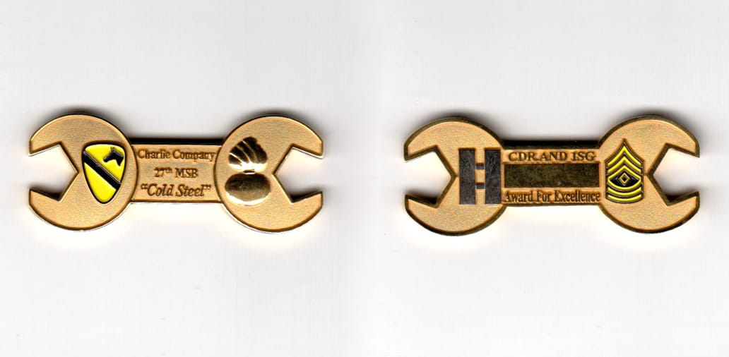 Wrench shaped, gold colored coin, 2 inches wide x 13/16 inches high.