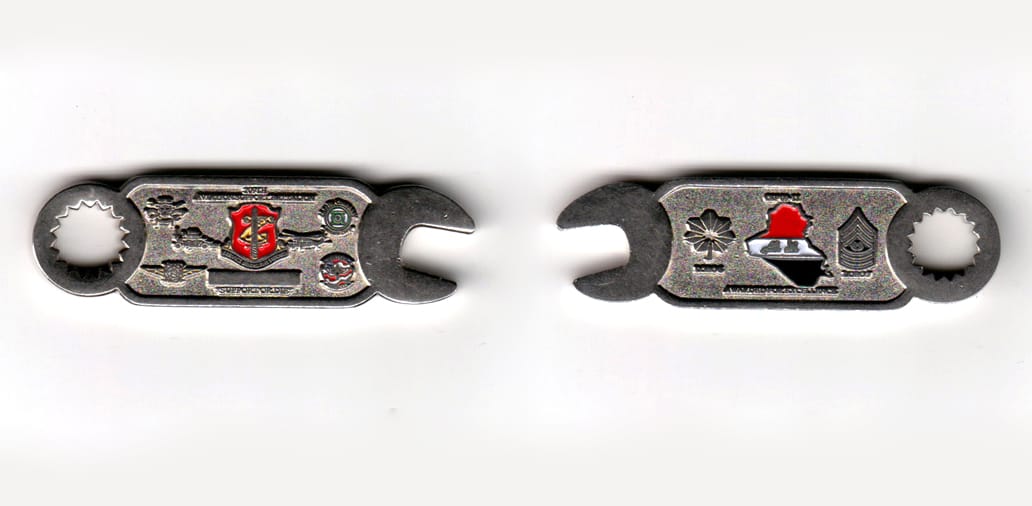 Wrench shaped, silver colored coin, 2-1/2 inches wide x 11/16 inches high.