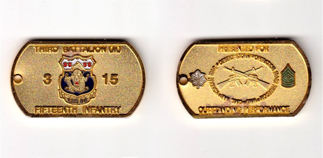 Dog tag shaped, gold colored coin, 2-1/8 inches wide x 1-1/8 inches high.
