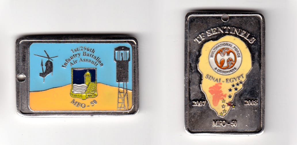 Dog tag shaped, silver colored coin, 2 inches wide x 1-1/4 inches high.