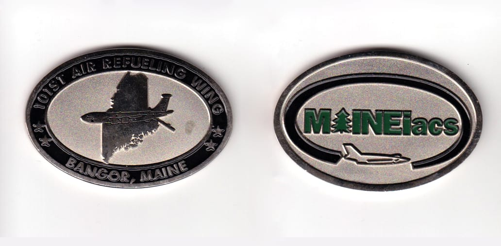 Oval shaped, silver colored coin, 2-1/4 inches wide x 1-1/2 inches high.