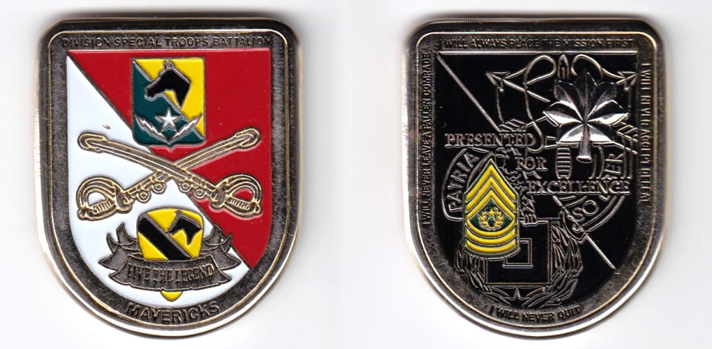 Shield shaped, gold colored coin, 1-5/8 inches wide x  2 inches high.