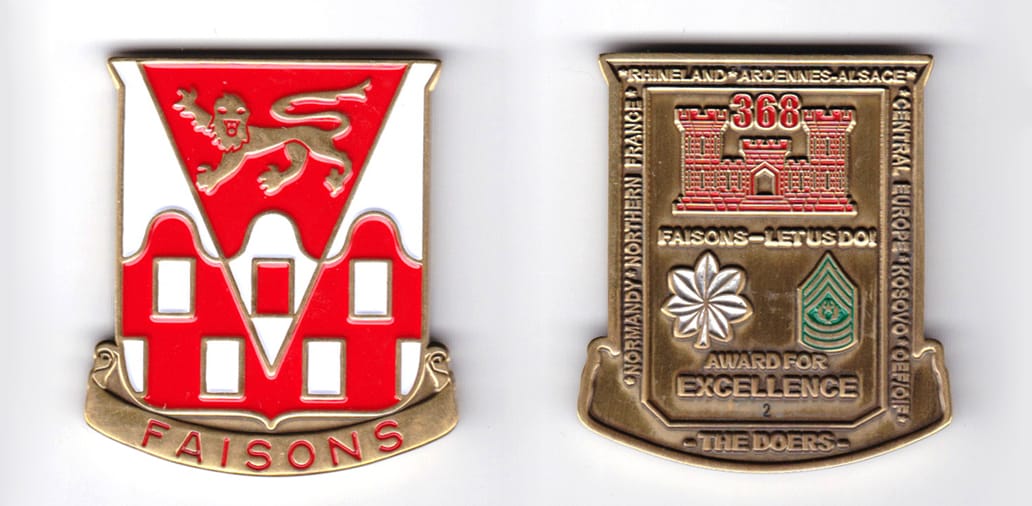 Shield shaped, with banner mounted brass colored coin, 1-3/4 inches wide x  2 inches high.