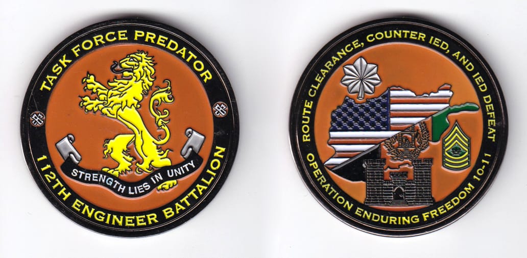 Round shaped, gun metal colored coin, 2 inches in diameter.