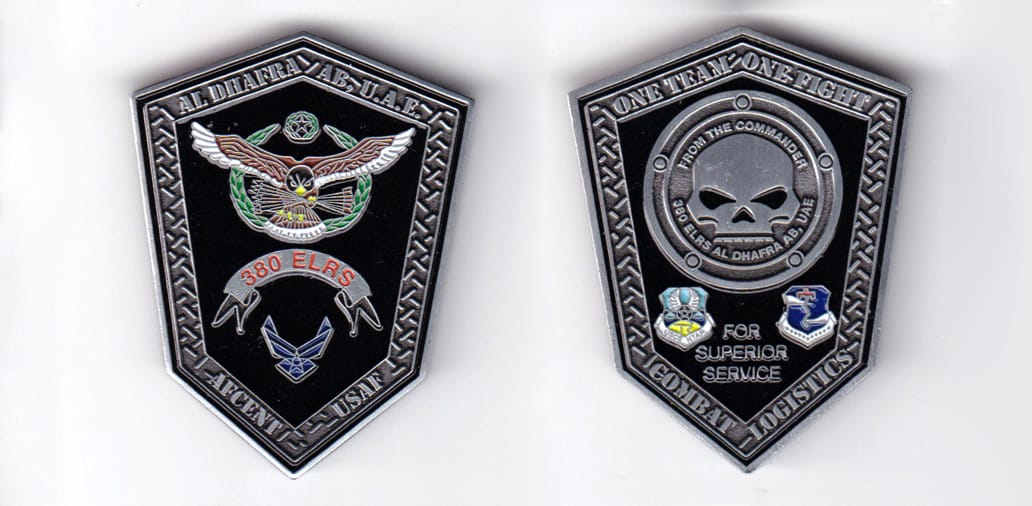 Shield shaped, pewter colored coin, 1-5/8 inches wide x  2 inches high.